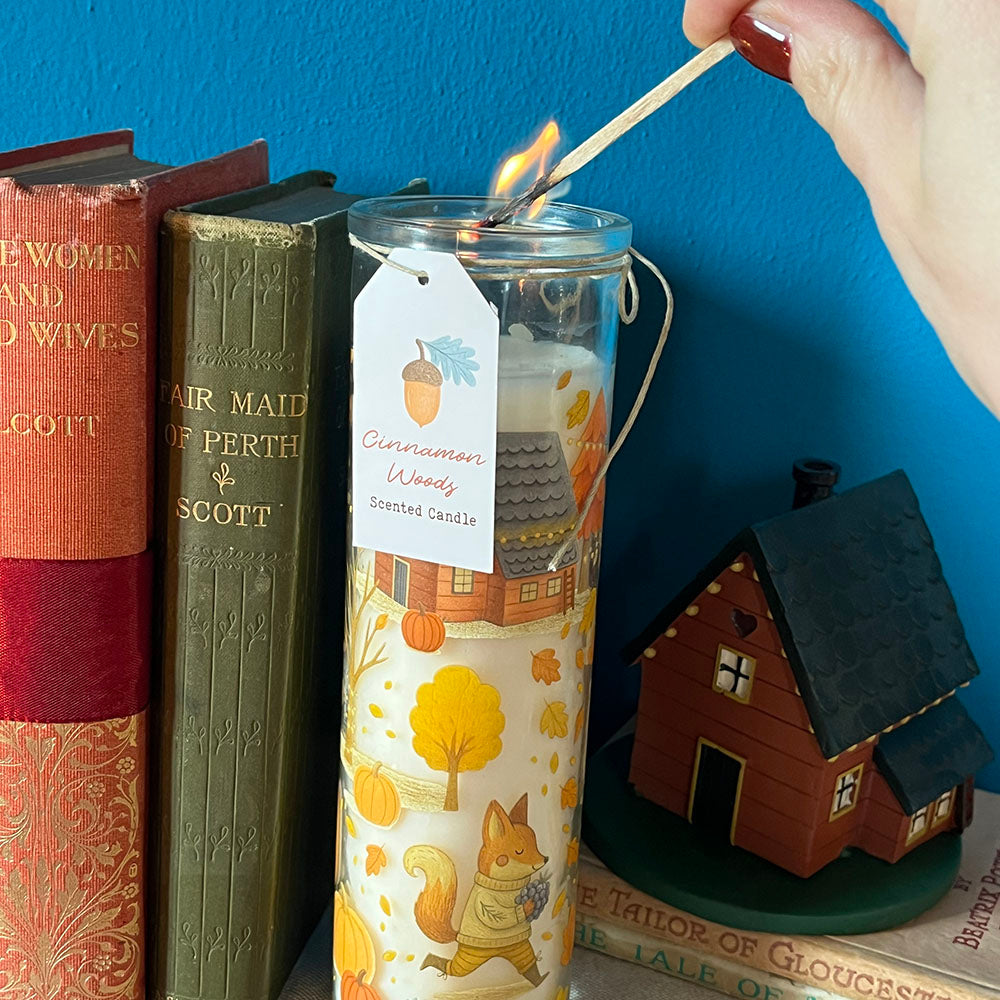 Candela profumata "Cinnamon Woods", tubo in vetro decorato con foglie, zucche e animali del bosco d'autunno